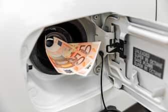 transportation expenses concept - euro money in car fuel tank