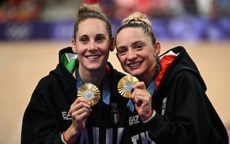 Gold medallists Italy's Vittoria Guazzini (L) and Italy's Chiara Consonni pose on the podium of the women's track cycling madison event of the Paris 2024 Olympic Games at the Saint-Quentin-en-Yvelines National Velodrome in Montigny-le-Bretonneux, south-west of Paris, on August 9, 2024. (Photo by SEBASTIEN BOZON / AFP)