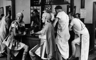 17th July 1948:  Staff and students at London's Goldsmith's College Art School having a drink at the bar dressed as Romans during their end of term 'Roman Holiday' theme day. Original Publication: Picture Post - 4585 - A Roman Holiday - pub. 1948  (Photo by Bert Hardy/Picture Post/Hulton Archive/Getty Images)