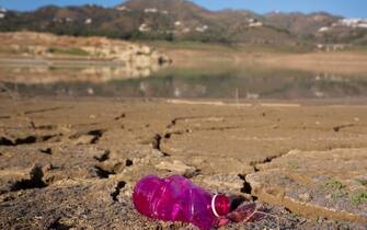 epa10708218 An empty plastic bottle at the La Vinuela reservoir in Malaga province, Andalusia region, southern Spain, 23 June 2023. The province of Malaga faces a heat wave with the reservoirs at 30.98 percent of their capacity.  EPA/ALVARO CABRERA
