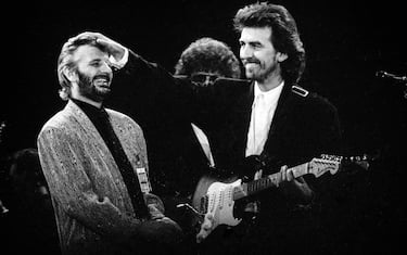 Ringo Starr and George Harrison perform during a concert for the Princes Trust, attended by Princess Diana and Prince Charles, at Wembley Stadium, London, circa 1987 (Photo by Dave Hogan/Getty Images)