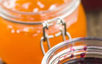 Fruity jam jelly in jar on old wooden table.