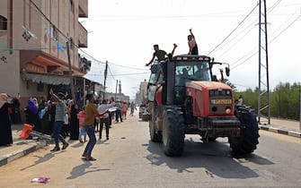Palestinians drive an Israeli tractor that was seized after crossing the border fence with Israel from Khan Yunis in the southern Gaza Strip on October 7, 2023. Barrages of rockets were fired at Israel from the Gaza Strip at dawn as militants from the blockaded Palestinian enclave infiltrated Israel, with at least one person killed, the army and medics said. (Photo by SAID KHATIB / AFP) (Photo by SAID KHATIB/AFP via Getty Images)