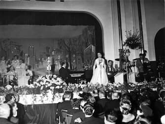 The Italian singer Jula De Palma (her complete name is Iolanda De Palma) is singing the song L'ombra at the 5th Sanremo Italian Song Festival; the song, interpreted with the singer Marisa Colomber, finishes eighth at the final night; at the piano Maestro Alberto Semprini. Sanremo (IM), Italy, January 1955. (Photo by Mondadori via Getty Images)