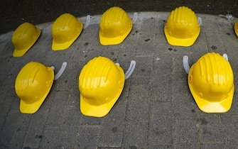 Iniziativa sindacale della Cisl di Napoli nella giornata mondiale per la sicurezza sul lavoro con l'esposizione su un marciapiede di 27 caschi gialli, lo stesso numero di morti sul lavoro registato nella provincia partenopea nel 2017, 27 aprile 2018. ANSA / CIRO FUSCO
