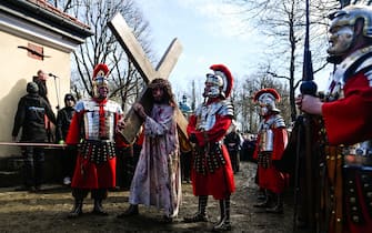 KALWARIA ZEBRZYDOWSKA, POLAND - MARCH 29: An actor playing Jesus carries a cross surrounded by actors dressed like soldiers take part in the Way of the cross during the Good Friday celebrations on March 29, 2024 in Kalwaria Zebrzydowska , Poland (Photo by Omar Marques/Anadolu via Getty Images)