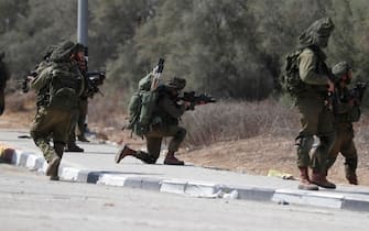 epa10911382 Israeli soldiers take position next to Kfar Aza kibbutz near the border with Gaza, 10 October 2023. More than 900 people have been killed, around 150 were taken as hostages, and 1,500 others injured, according to Israel Defence Forces (IDF), after the Islamist movement Hamas launched an attack against Israel on 07 October. More than 3,000 people, including 1,500 militants from Hamas, have been killed and thousands injured in Gaza and Israel since 07 October, according to Israeli military sources and Palestinian officials.  EPA/ATEF SAFADI