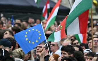 Protesters display the Hungarian and the European flag as they take part in a rally organised by Hungarian opposition figure Peter Magyar, Hungarian lawyer, former government insider and ex-husband of former Justice Minister Varga, in downtown Budapest on April 06, 2024, to denounce the Hungarian government and corruption. (Photo by Attila KISBENEDEK / AFP)