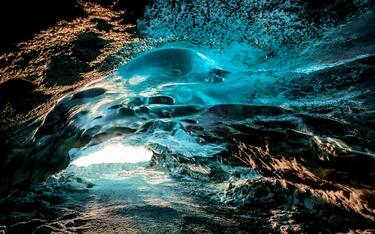 Emerald Blue Ice and Ash in The Crystal Cave which is part of Breidamerkurjokull, an outlet glacier of Vatnajokull- one of the largest ice caps in Europe, Eastern Iceland