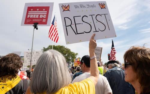 epa12462527 People gather on Pennsylvania Avenue to participate in the 'No Kings' protest in Washington, DC, USA, 18 October 2025. The protest is part of a nationwide 'No Kings' day of action, opposing what organizers see as authoritarian overreach and threats to democracy under US President Trump.  EPA/LUKE JOHNSON