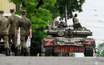epa10709278 Servicemen from private military company (PMC) Wagner Group block a street with a tank reading 'Siberia' in downtown Rostov-on-Don, southern Russia, 24 June 2023. Security and armoured vehicles were deployed after Wagner Group's chief Yevgeny Prigozhin said in a video that his troops had occupied the building of the headquarters of the Southern Military District, demanding a meeting with Russia s defense chiefs.  EPA/STRINGER