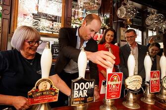 LONDON, ENGLAND - MAY 04: Prince William, Prince of Wales pulls the first pint of Kingmaker a new brew celebrating the coronation as Catherine, Princess of Wales looks on at the Dog and Duck pub in Soho ahead of this weekend's coronation on May 4, 2023 in London, England. (Photo by Jamie Lorriman - WPA Pool/Getty Images)