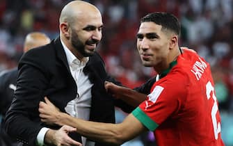 epa10352339 Head coach of Morocco Walid Regragui celebrates with Achraf Hakimi after the FIFA World Cup 2022 round of 16 soccer match between Morocco and Spain at Education City Stadium in Doha, Qatar, 06 December 2022.  EPA/Mohamed Messara