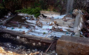 Una ventina di bare e 80 urne sono finite in un torrente in seguito al cedimento di un'ala del cimitero. È accaduto a S. Agata dei Goti, in provincia di Benevento, 19 gennaio 2023. 
ANSA