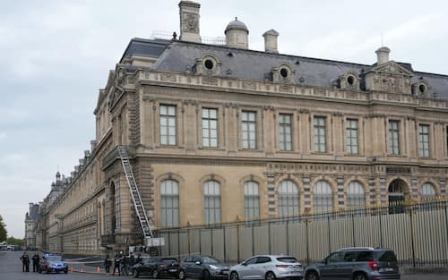 French police officers stand next to a furniture elevator used by robbers to enter the Louvre Museum, on Quai Francois Mitterrand, in Paris on October 19, 2025. Robbers broke in to the Louvre and fled with jewellery on October 19, 2025 morning, a source close to the case said, adding that its value was still being evaluated. A police source said an unknown number of thieves arrived on a scooter armed with small chainsaws and used a goods lift to reach the room they were targeting. (Photo by Dimitar DILKOFF / AFP)