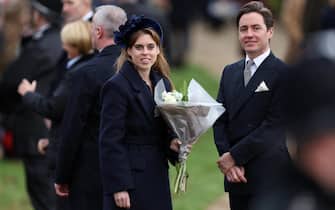 Britain's Princess Beatrice of York (L) and Edoardo Mapelli Mozzi (R) wait outside after attending the Royal Family's traditional Christmas Day service at St Mary Magdalene Church on the Sandringham Estate in eastern England, on December 25, 2023. (Photo by Adrian DENNIS / AFP)