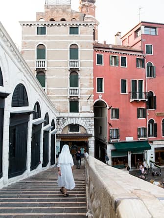 A nun walking down stairs on the Rialto Bridge in Venice, Italy