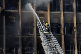 EDITORS NOTE: Graphic content / A firefighter extinguishes the fire at a building in Johannesburg on August 31, 2023. At least 20 people have died and more than 40 were injured in a fire that engulfed a five-storey building in central Johannesburg on August 31, 2023, the South African city's emergency services said. (Photo by Michele Spatari / AFP) (Photo by MICHELE SPATARI/AFP via Getty Images)