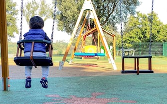 Un bambino gioca da solo sull'altalena di un parco a Roma 26 ottobre 2023. ANSA/ALESSANDRO DI MEO (figlio unico, figli unici, solitudine, bambino, bambini, famiglia, giochi, gioco, assegno unico, natalita' )