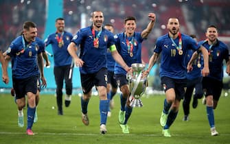 Italy's Giorgio Chiellini and Leonardo Bonucci carry the trophy and celebrate with team-mates after winning the penalty shoot-out after the UEFA Euro 2020 Final at Wembley Stadium, London. Picture date: Sunday July 11, 2021.  PA Photo. See PA story SOCCER England. Photo credit should read: Nick Potts/PA Wire.

RESTRICTIONS: Use subject to restrictions. Editorial use only, no commercial use without prior consent from rights holder.