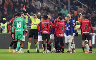 MILAN, ITALY - APRIL 22: Match referee Andrea Colombo shows a red card to Theo Hernandez of AC Milan (obscured) during the Serie A TIM match between AC Milan and FC Internazionale at Stadio Giuseppe Meazza on April 22, 2024 in Milan, Italy. (Photo by Marco Luzzani/Getty Images)