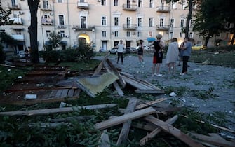 People stand among the debris outside a residential building after a missile strike in Odesa, early on July 23, 2023. At least one person was killed and more than 15 wounded in a Russian attack on the southern Ukrainian port city of Odesa, the governor of the region said. (Photo by Oleksandr GIMANOV / AFP) (Photo by OLEKSANDR GIMANOV/AFP via Getty Images)