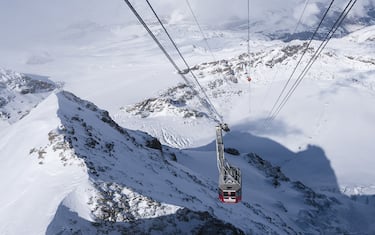 Klein Matterhorn, Switzerland - February 19, 2016: A cable car is approaching Europe's highest cable car station on top of Klein Matterhorn (Matterhorn Glacier Paradise, 3883m altitude) while the peak of Klein Matterhorn casts a shadow on the snow covered Theodul Glacier below.