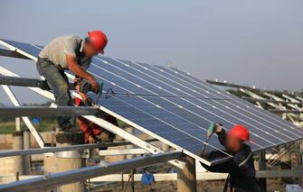 HUAI AN, CHINA - JUNE 11:  Workers install solar panels at the construction site of 40MW photovoltaic on-grid power project of China Huaneng Group on June 11, 2018 in Huai an, China. The first phase with installed capacity of 30 megawatts will be put into operation at the end of June this year.  (Photo by VCG/VCG via Getty Images)