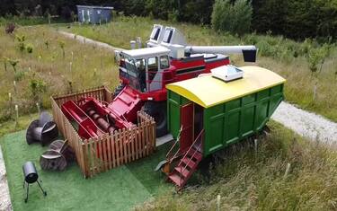 Story from Jam Press (Holiday Home Harvester) 

Pictured: Outside the old combine harvester turned into a quirky holiday home.

Farmer spends £20,000 transforming old combine harvester into quirky holiday home

A farmer has spent £20,000 transforming his old combine harvester into a quirky holiday home.

Will Roughton purchased the Massey Ferguson 860 for £5,000.

It was previously used to harvest 20 tonnes of wheat per hour on a family farm.

But the savvy 46-year-old decided he could make better use of it.

Will spent four months converting the farming machinery into a cosy BnB on his campsite.

The first task was taking out all the working parts of the combine - he called Kaleb.

Will, of Friskney, near Skegness, Lincolnshire says he had to hollow out the machine so he had an “empty shell” to work with.

But he had to leave the engine in so he could drive it into a spot on his campsite.

Once it was empty, Will began to add insulation, under-floor heating and wiring to transform it into a liveable space.

Will also converted a grain trailer which sits underneath Kaleb’s spout.

He then added in furniture such as a king-sized bed, kitchen counter, a staircase and fridge.

The farmer wanted to keep the decor agricultural theme.

He crafted shelves and even a dog bed for four-legged guests from the farm’s vintage chitting trays -used to seed potatoes.

The windows were made from up-cycled grain-hatch lids.

Will says the upgrade was hard work and he ran into a few issues with the weather.

But after months of hard work, the transformation was a success.

The property sleeps up to four guests.

There is also a communal facilities block, with toilets and hot showers, close by.

It costs £120 per night to stay in.

It is situated on Will’s campsite – which is an old RAF base.

RAF Wainfleet went out of use in 2010.

The Lincolnshire site was purchased from the Ministry of Defence by the farmer who owned the access road.

There are other bizarre accommodations available to rent on site including a WW2 tank, ambulance and RAF watchtower.

The RAF tower was once used to observe the bombing range on the training ground.

Will says the cost of the combined harvester and the renovations set him back a total of £20,000.

Will told What's The Jam: “I’m absolutely not experienced in this kind of thing.

”I looked at it from the outside and thought you could fit a bed in there.

”So I stripped it from the inside out.

”Once it was hollowed out, I could look at it as a house and fit it with insulation and wiring.”

He added: “We have a mixed bag of guests.

”We have had a lot of couples coming and staying as well as families.

”I did this for kids - they got so excited seeing me in a tractor.

”It’s a picturesque location just seven miles from Skegness.

”We’re near the beach, lakes where people can paddleboard.

”It’s a very peaceful location.”

ENDS

EDITOR’S NOTE: Video Usage Licence: (EXCLUSIVE) We have obtained an exclusive licence from the copyright holder. A copy of the licence is available on request.

Video Restrictions: None.