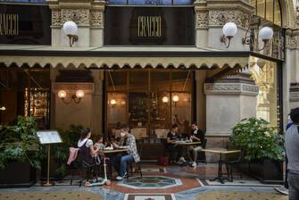 Gente seduta ai tavolini da Cracco in galleria il lunedì mattina della riapertura dopo il lockdown a causa del coronavirus Covid-19