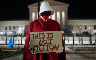 epa10033049 A protester stands outside the Supreme Court after sunset in Washington, DC, USA, 24 June 2022. The US Supreme Court ruled on the Dobbs v Jackson Women's Health Organization, overturning the 1973 case of Roe v Wade that guaranteed federal abortion rights.  EPA/WILL OLIVER