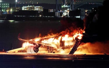 TOPSHOT - This photo provided by Jiji Press shows a Japan Airlines plane on fire on a runway of Tokyo's Haneda Airport on January 2, 2024. A Japan Airlines plane was in flames on the runway of Tokyo's Haneda Airport on January 2 after apparently colliding with a coast guard aircraft, television reports said. (Photo by JIJI PRESS / AFP) / Japan OUT (Photo by STR/JIJI PRESS/AFP via Getty Images)