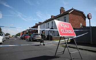 epa11506091 A paramedic walks behind a 'road closed' sign in Hart Street in Southport, Britain, 29 July 2024. Armed police detained a male and seized a knife after a number of people were injured in a reported stabbing according to Merseyside Police. Eight patients with stab injuries have been treated at the scene so far and have been taken to hospitals, North West Ambulance Service said.  EPA/ADAM VAUGHAN