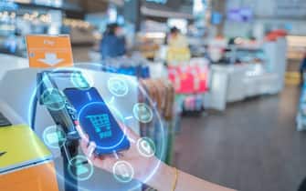 Internet of Things and Mobile Payment concept,close up hand holding smart phone with Communication icons.Paying through terminal.Connection and wireless network Technology