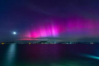epa11332610 The Northern Lights, or aurora borealis, illuminate the night sky over Lake Balaton near Fonyod, Hungary, 10 May 2024 (issued 11 May 2024). The Northern lights, or aurora borealis, were also visible in the sky of Hungary after an 'extreme' solar storm began to hit the Earth on 10 May.  EPA/GYORGY VARGA HUNGARY OUT
