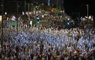 epa10543085 Protesters with Israeli flags during a mass protest against the government's justice system reform plans in Tel Aviv, Israel, 25 March 2023. Nationwide anti-government protests have been sparked by Israeli government plans to reform the justice system and limit the power of the Supreme Court.  EPA/ABIR SULTAN