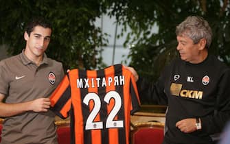 Head coach of Shakhtar Donetsk Mircea Lucescu (R) and Armenian footballer Henrikh Mkhitaryan hold a shirt of his new football club Shakhtar Donetsk during press conference in Donetsk on September 9, 2010. AFP PHOTO / Alexander KHUDOTEPLY (Photo credit should read Alexander KHUDOTEPLY/AFP via Getty Images)