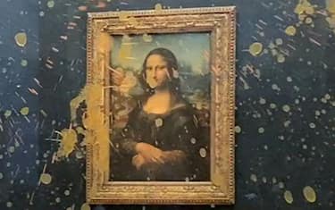 This image grab taken from AFPTV footage shows Leonardo Da Vinci's "Mona Lisa" (La Joconde) painting doused in soup after two environmental activists from the collective dubbed "Riposte Alimentaire" (Food Retaliation) hurled food at the artwork, at the Louvre museum in Paris, on January 28, 2024. Two protesters on January 38, 2024 hurled soup at the bullet-proof glass protecting Leonardo da Vinci's "Mona Lisa" in Paris, demanding the right to "healthy and sustainable food", an AFP journalist said. It is the latest attack on the masterpiece in the French capital's Louvre museum, after someone threw a custard pie at it in May 2022, but it's thick glass casing ensured it came to no harm. (Photo by David CANTINIAUX / AFPTV / AFP) (Photo by DAVID CANTINIAUX/AFPTV/AFP via Getty Images)