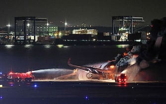 This photo provided by Jiji Press shows firefighters attempting to extinguish a fire on a Japan Airlines plane on a runway of Tokyo's Haneda Airport on January 2, 2024. A Japan Airlines plane was in flames on the runway of Tokyo's Haneda Airport on January 2 after apparently colliding with a coast guard aircraft, television reports said. (Photo by JIJI PRESS / AFP) / Japan OUT (Photo by STR/JIJI PRESS/AFP via Getty Images)