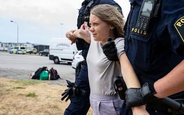Police officers carry Swedish climate activist Greta Thunberg away together with other climate activists from the organization 'Ta Tillbaka Framtiden' (Take Back the Future), who block the entrance to Oljehamnen neighbourhood in Malmo, Sweden, on June 19, 2023, for the 5th day in a row. (Photo by Johan NILSSON / TT News Agency / AFP) / Sweden OUT (Photo by JOHAN NILSSON/TT News Agency/AFP via Getty Images)