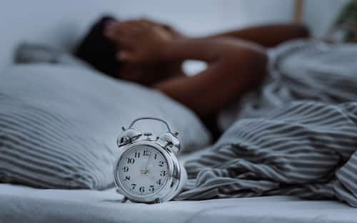 African american woman suffering from insomnia lying in bed without sleep.