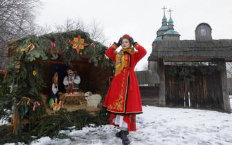 epa11044035 A Ukrainian woman in traditional attire stands next to a nativity scene in Pyrogovo village, near Kyiv (Kiev), Ukraine, 25 December 2023, amid the Russian invasion. Ukraine celebrates Christmas on 25 December for the first time this year, in accordance with the Western calendar. Ukrainian President Zelensky signed a law in July to move the official Christmas Day holiday to 25 December, departing from the Russian Orthodox Church tradition of celebrating on 07 January. Russian troops entered Ukraine on 24 February 2022 starting a conflict that has provoked destruction and a humanitarian crisis.  EPA/SERGEY DOLZHENKO