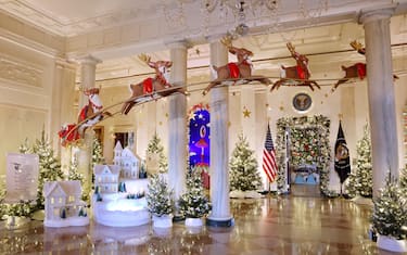 WASHINGTON, DC - NOVEMBER 27: Santa Clause in his sleigh and a team of reindeer fly through the columns of the Entrance Hall during a media preview of the 2023 holiday decorations at the White House November 27, 2023 in Washington, DC. The theme for this year's White House decorations is â  Magic, Wonder and Joy,â   and is designed to capture the â  delight and imagination of childhood.â   The White House expects to welcome approximately 100,000 visitors during the holiday season. (Photo by Kevin Dietsch/Getty Images)