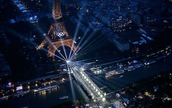 A photograph taken from an helicopter on July 26, 2024 shows an aerial view of the Eiffel Tower and the Olympics Rings lightened up during the opening ceremony of the Paris 2024 Olympic Games in Paris. (Photo by Lionel BONAVENTURE / POOL / AFP) (Photo by LIONEL BONAVENTURE/POOL/AFP via Getty Images)