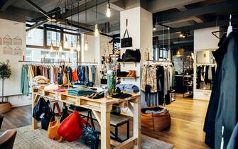 The retail displays and items of clothing on display in a fashionable high street clothing store, with no people.