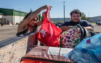 Hay River fire evacuees Tanisha Edison and her boyfriend Mason Bruneau go through their belongings at the evacuee centre in St. Albert, Alta. on Wednesday, August 16, 2023. Photo by Jason Franson/CP/ABACAPRESS.COM