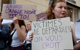 A protesters holds  a placard reading "Victims of Depardieu, we believe you"  during a demonstration by feminist activist group members outside the Femina theatre where French actor Gerard Depardieu, of whom allegations of rape have been made against him, is performing the concert "Depardieu chante Barbara", in Bordeaux, southwestern France, on May 24, 2023. (Photo by ROMAIN PERROCHEAU / AFP) (Photo by ROMAIN PERROCHEAU/AFP via Getty Images)