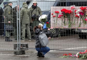epa11238295 A woman brings flowers to the burned Crocus City Hall concert venue following a terrorist attack in Krasnogorsk, outside Moscow, Russia, 23 March 2024.  On 22 March evening, a group of up to five gunmen attacked the Crocus City Hall in the Moscow region, Russian emergency services said. 93 people were killed and more than 100 others were hospitalized, the Investigative Committee confirmed. The head of the Russian FSB, Alexander Bortnikov, reported to Russian President Vladimir Putin on 23 March on the arrest of 11 people, including all four terrorists directly involved in the terrorist attack.  EPA/MAXIM SHIPENKOV