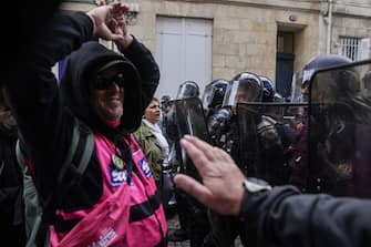 A protester faces off with riot police during a demonstration on May Day (Labour Day), to mark the international day of the workers, more than a month after the government pushed an unpopular pensions reform act through parliament, in Bordeaux, southwestern France, on May 1, 2023. - Opposition parties and trade unions have urged protesters to maintain their three-month campaign against the law that will hike the retirement age to 64 from 62. (Photo by Thibaud MORITZ / AFP) (Photo by THIBAUD MORITZ/AFP via Getty Images)