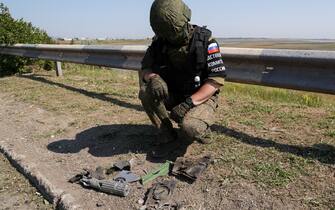 RUSSIA, KHERSON REGION - JUNE 23, 2023: An employee of the Russian Investigative Committee collects projectile fragments on a bridge damaged by a Ukrainian strike near the village of Chongar. According to acting Kherson Region Governor Saldo, Ukraine has hit bridges between the region and Crimea, using what appears to be British cruise missiles Storm Shadow. Alexander Polegenko/TASS/Sipa USA